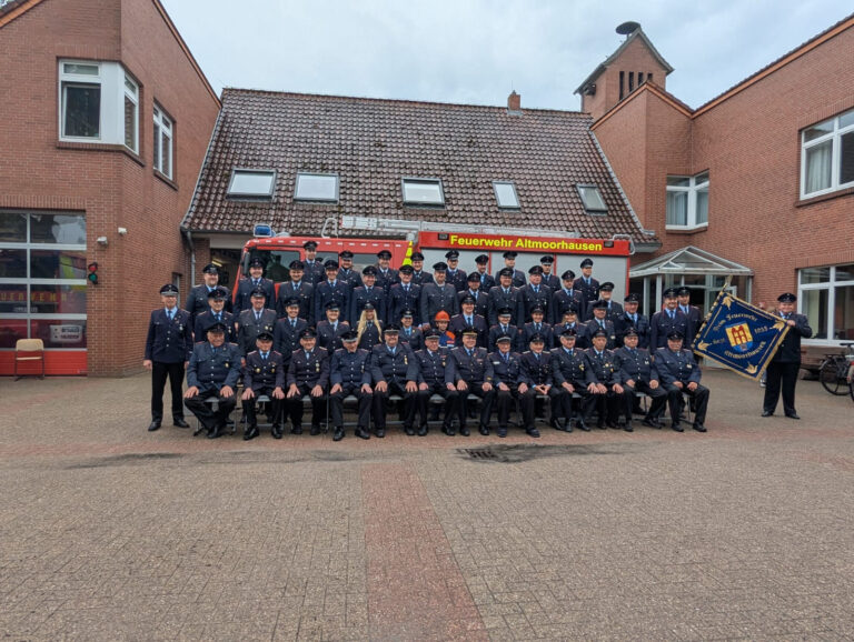 Gruppenfoto der Ortswehr Altmoorhausen in Uniform vor ihrem Feuerwehrhaus
