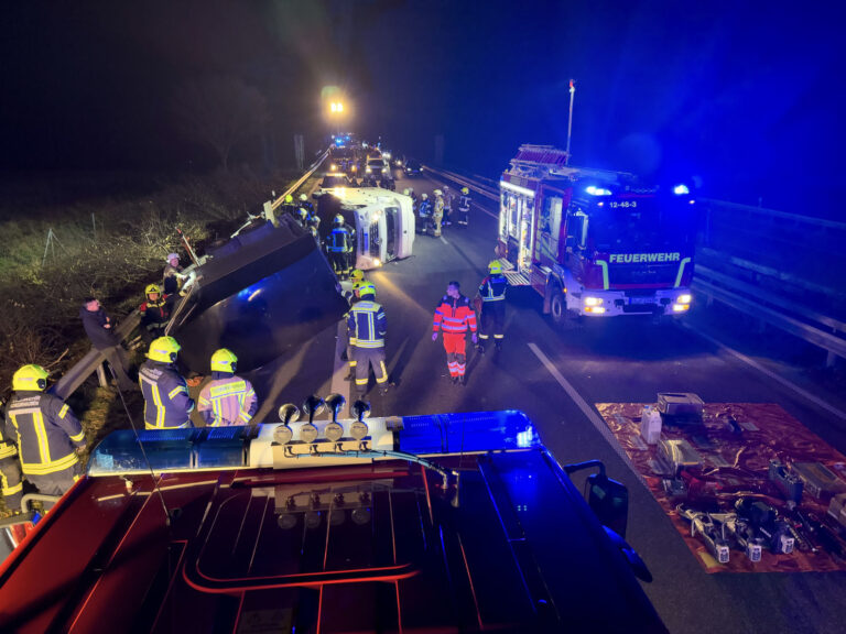 Nächtliche Unfallstelle auf der A28 mit umgekipptem Pferdeanhänger und Feuerwehrfahrzeugen im Blaulicht