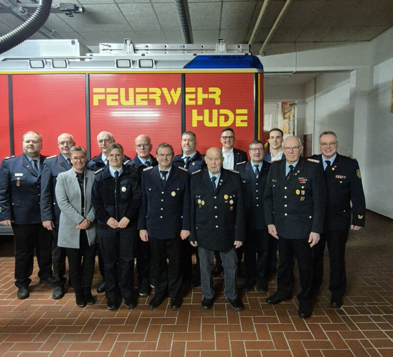Mitglieder der Ortswehr Hude in Uniform vor einem Löschfahrzeug